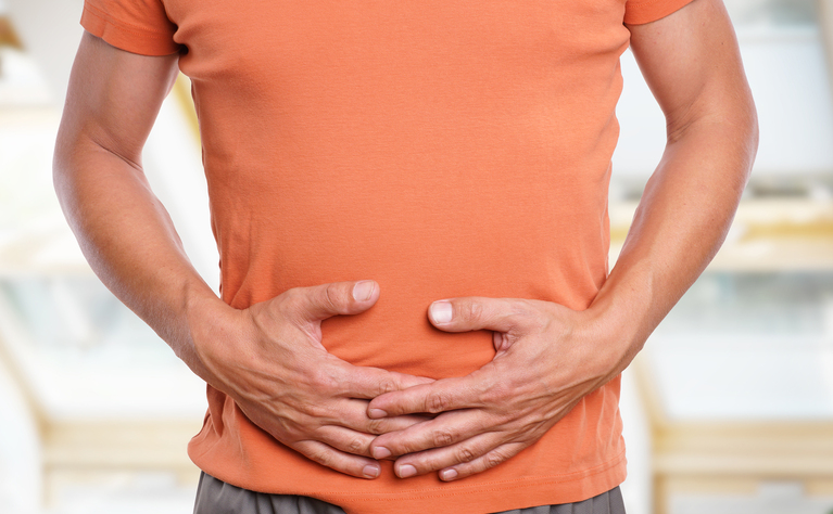 Man with trapped wind holding stomach